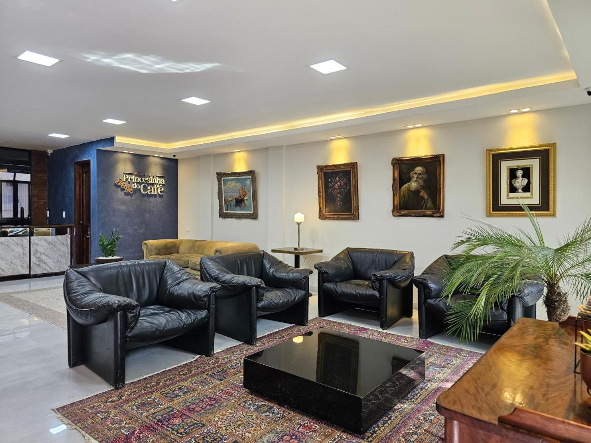 Recepção do Hotel Princesinha do Café, com quadros clássicos, tapete persa e sofás de couro